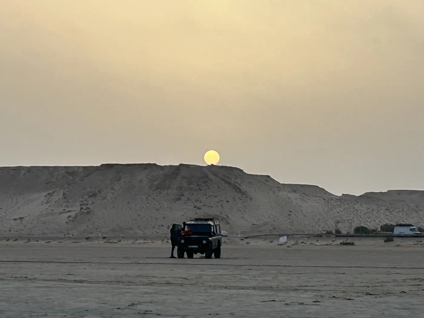 Le 4x4 au pied des dunes, au soleil couchant